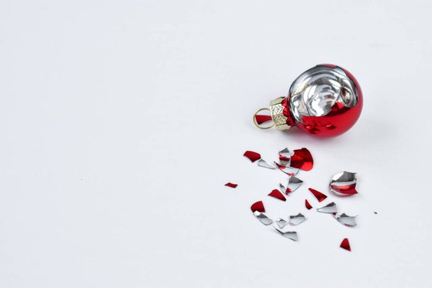 Broken Christmas ball in red on a white background. The view from the top. - Foto, Bild