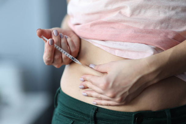 Woman gives an injection in the stomach. - Foto, Imagem