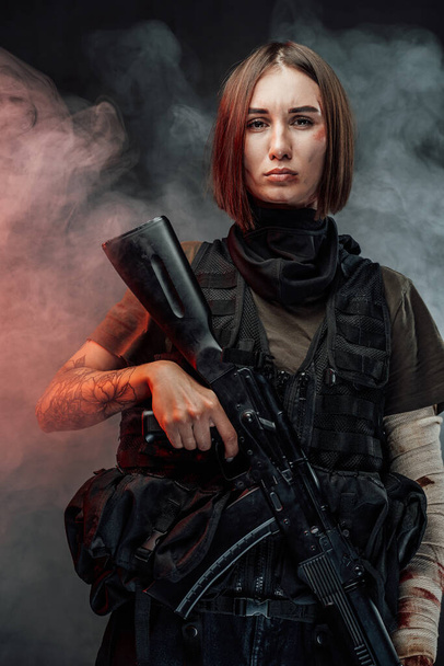 Bella donna marziale con fucile in fumoso e sfondo scuro - Foto, immagini
