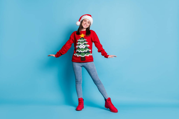 Full body size photo of adorable charming lady girlish posing shiny smiling wear santa x-mas headwear red ornamented pullover jeans boots isolated blue color background - Valokuva, kuva