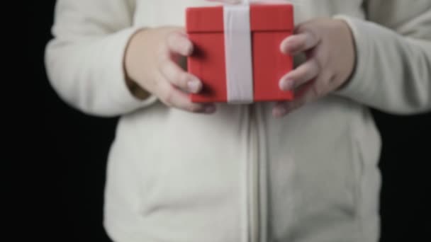kleine meisjes handen geven rode geschenkdoos met wit lint. Kerstmis, nieuwjaar - Video