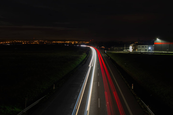 赤と白の色で高速道路上の車両の車のライトトレイル。夜の交通量長時間露光 - 写真・画像