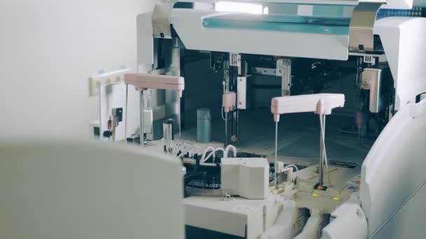 Travaux de l'analyseur biochimique en laboratoire close up. tubes à essai qui sont automatiquement envoyés pour examen - Séquence, vidéo
