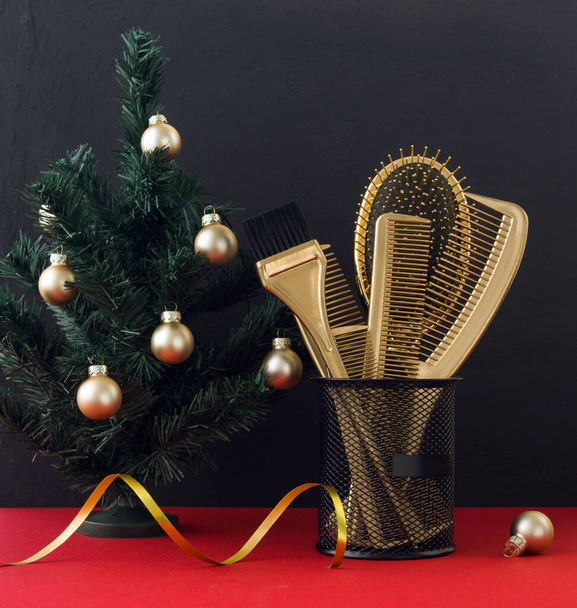 Tarjeta navideña con accesorios de peluquería dorada y árbol de Navidad. Peines de peluquería en el estrado. Foto de vacaciones. - Foto, imagen