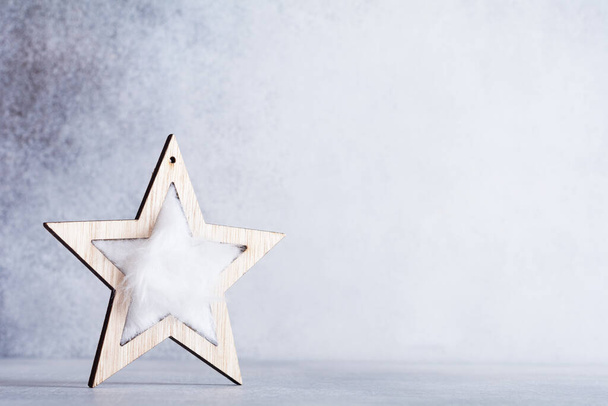 Christmas background with wooden star on light gray background. Eco friendly, zero waste Christmas. - Foto, Imagem