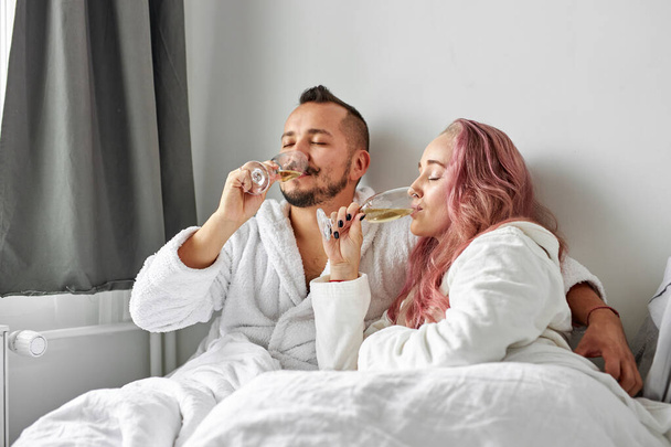 beautiful couple have romantic time on bed drinking champagne - Foto, Bild