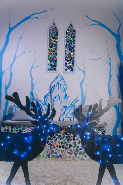 Interior del castillo de hielo. Dos vidrieras de estilo medieval. Árboles azules en la pared. Sofá del trono hecho de nieve. - Foto, imagen