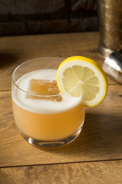 Boozy Refreshing Egg White Whiskey Sour with Lemon - 写真・画像