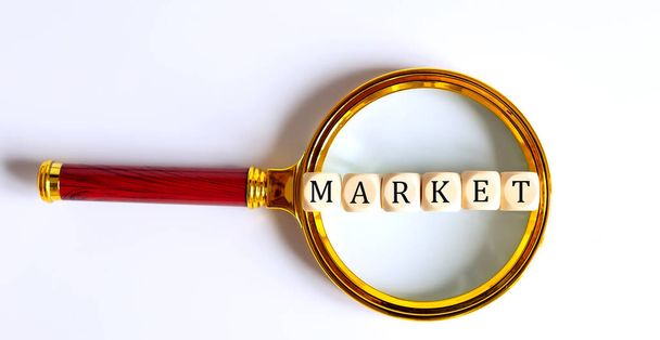 Wooden Blocks with the text: MARKET on magnifying glass. - Photo, Image