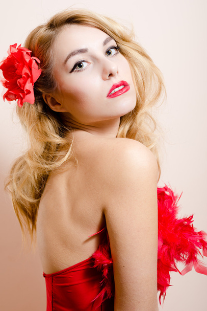 elegante romantische sexy blonde Frauen mit grünen Augen in rotem Kleid mit Rose im Haar - Foto, Bild