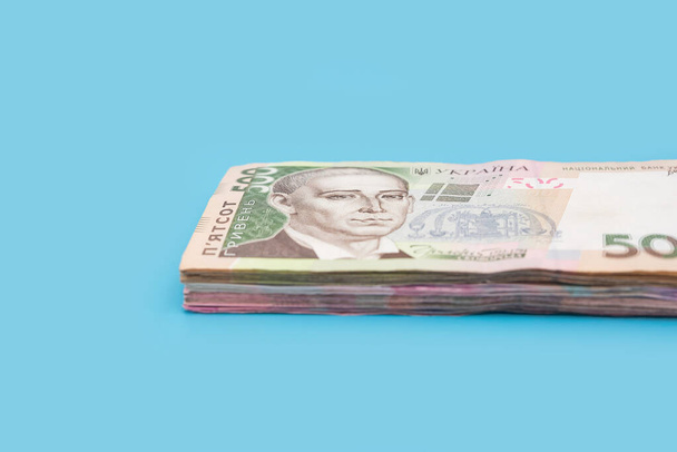 stos ukraińskich hrywien na niebieskim tle. 500 banknotów hrywien. Koncepcja finansowa. - Zdjęcie, obraz