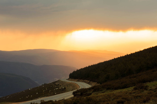 landschapsweg tussen bergen en groene vallei bij zonsondergang. Hoge kwaliteit foto - Foto, afbeelding