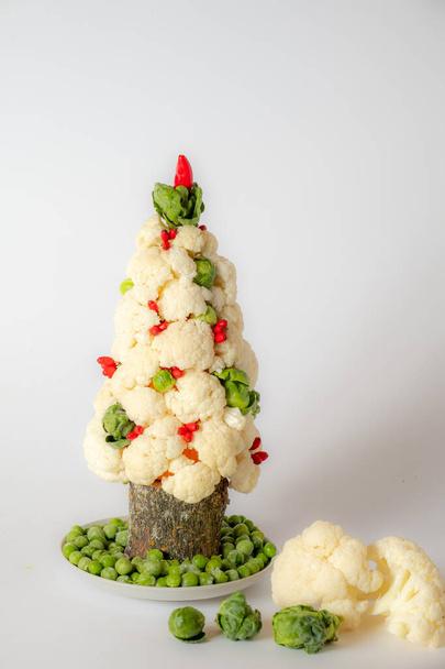 Рождественская елка овощ из капусты на белом фоне. Поблизости овощи. Новогодняя концепция и пространство для копирования. - Фото, изображение