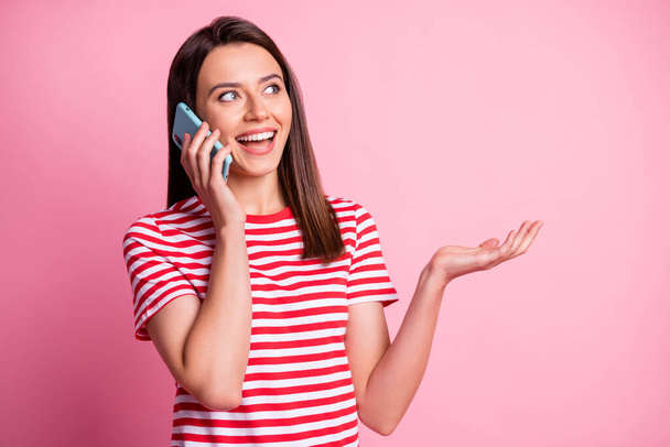 Photo of nice smiling young brown hair lady talk telephone show empty space isolated over pink background - Fotoğraf, Görsel