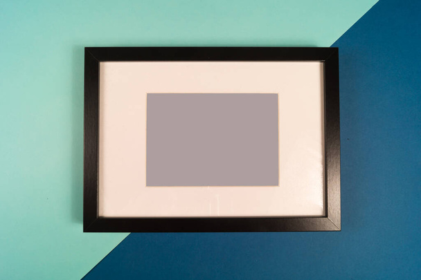 Moldura de foto preta vazia em fundo de cor branca e azul, com espaço de cópia. - Foto, Imagem
