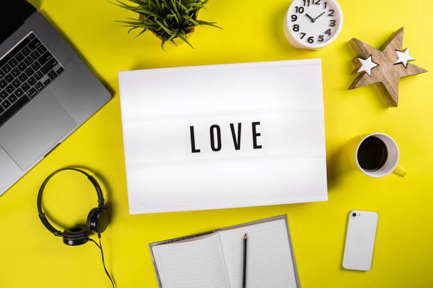 Love message on lightbox on modern yellow office desktop with laptop - Zdjęcie, obraz