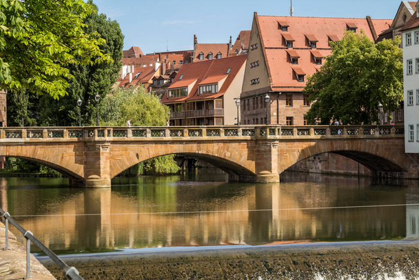 ドイツ・ニュルンベルクのペグニッツ川に架かるドイツの伝統的な旧市街の建築と橋 - 写真・画像