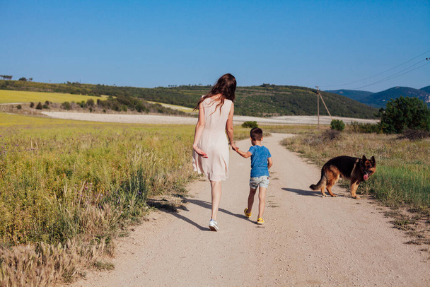 Äiti ja poika kävellä Saksanpaimenkoira - Valokuva, kuva