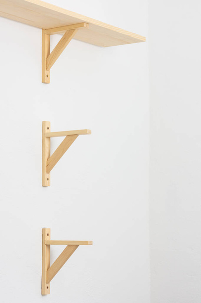 The process of attaching a wooden shelf to the wall, shelf corners - Photo, Image