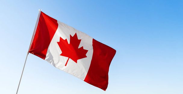 Flag of Canada waving against blue sky - Foto, Imagem