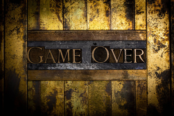 Mensaje de texto de Game Over sobre cobre grunge texturizado y fondo dorado vintage - Foto, imagen