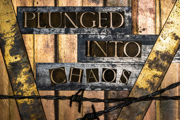 Plunged Into Chaos text message on vintage textured grunge copper and bronze background with barbed wire - Photo, Image