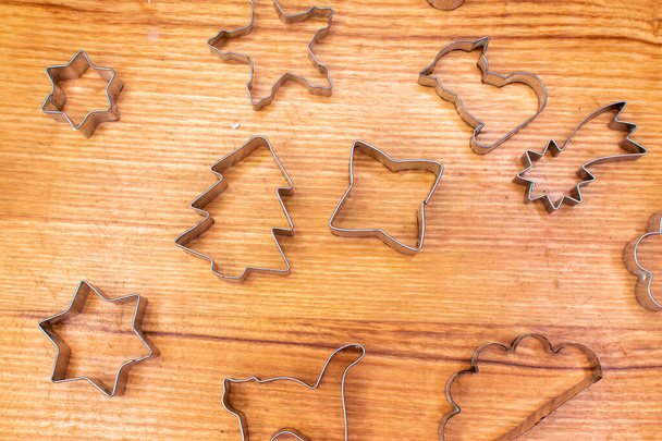 Gingerbread aluminum cookie cutters on wooden board - Photo, image