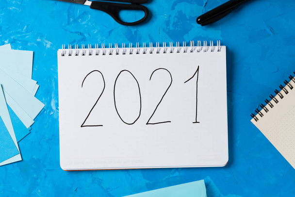 Resolución de Año Nuevo Lista de objetivos 2021 sobre fondo azul con cuaderno y chansellery. - Foto, Imagen