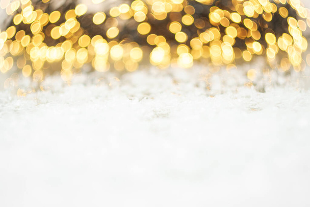 Bokeh parpadeante de luces de brillo dorado y nieve. Fondo de Navidad. Fiesta de año nuevo.  - Foto, imagen