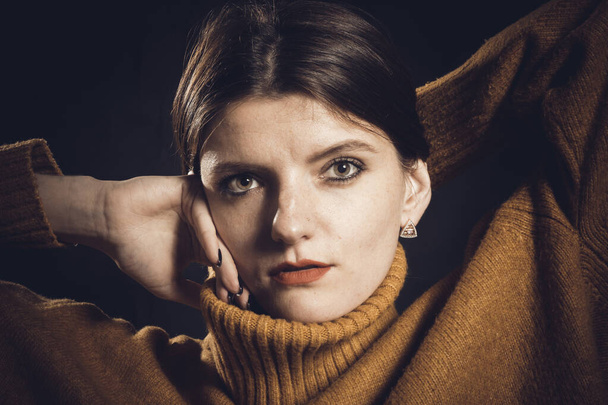 Studio portrait of young beautiful woman dressed in sweater - Fotoğraf, Görsel
