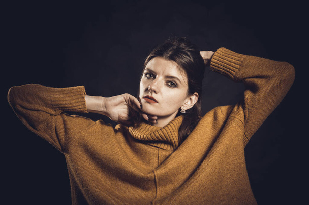 Studio portrait of young beautiful woman dressed in sweater - Zdjęcie, obraz