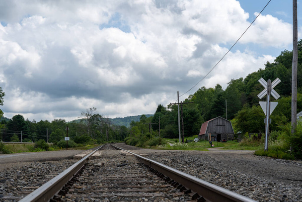 A railroad crossing at an old barn in the rural countryside. - Фото, зображення