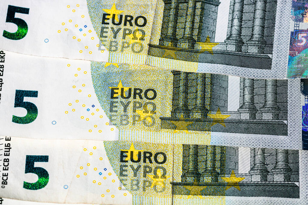 Selektiver Fokus auf die Details der Euro-Banknoten. Makrodetails von Geldscheinen aus nächster Nähe, 5-Euro-Scheine isoliert. Weltwährungskonzept, Inflation und Wirtschaftskonzept - Foto, Bild