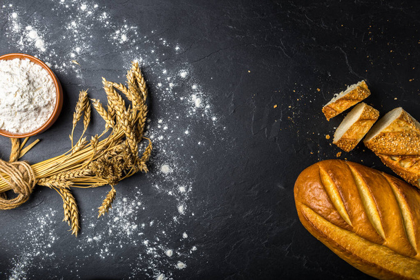 Bakery products and wheat flour black on slate - Фото, зображення