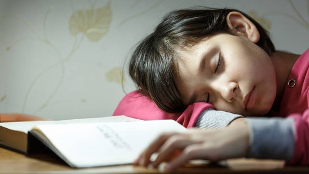 Menina adormeceu fazendo lição de casa à noite. - Foto, Imagem