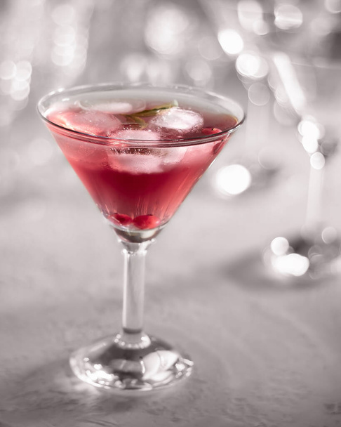 A glass of cocktail with red currants and ice, with bokeh in the background - 写真・画像