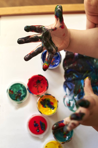Mains d'un enfant qui peint avec des peintures brillantes doigt, le développement précoce de l'enfant. - Photo, image