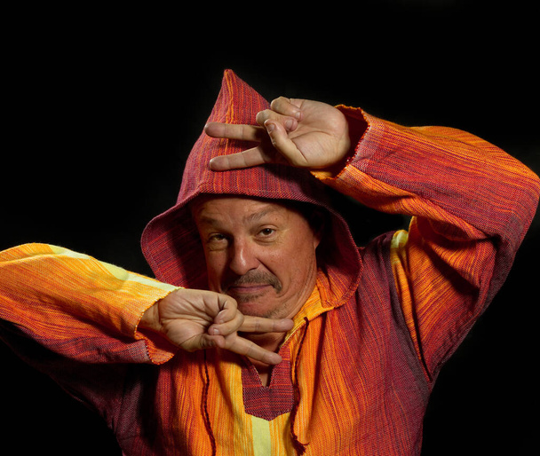 Middle aged man in bright orange clothe dancing - Foto, Imagen