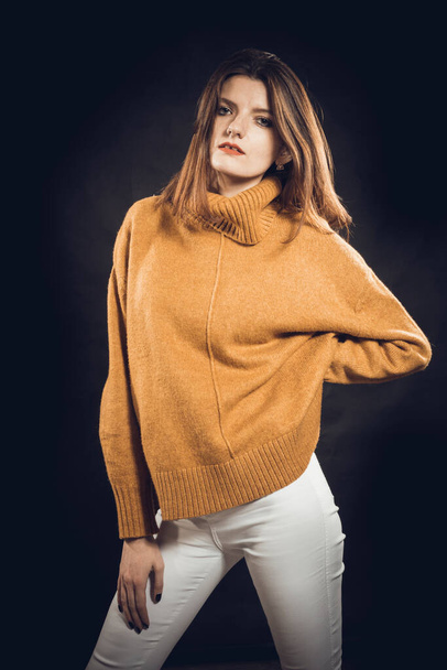 Studio portrait of young beautiful woman dressed in sweater - Foto, imagen