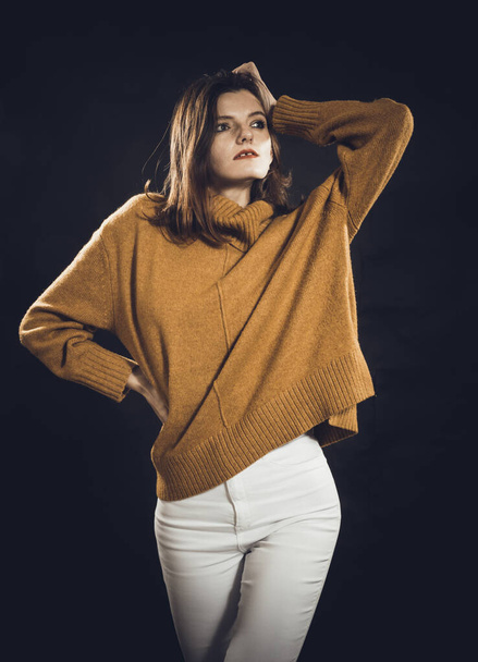 Studio portrait of young beautiful woman dressed in sweater - Φωτογραφία, εικόνα