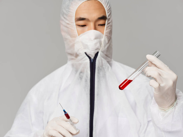 человек азиатской внешности лабораторные исследования медицины вакцины серый фон - Фото, изображение