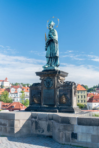 Πράγα, Τσεχία - 10 Ιουλίου 2020: Το άγαλμα του Ιωάννη του Νεπομούκ στη Γέφυρα του Καρόλου. - Φωτογραφία, εικόνα