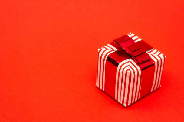 Gift box with a bow isolated on red background - Zdjęcie, obraz