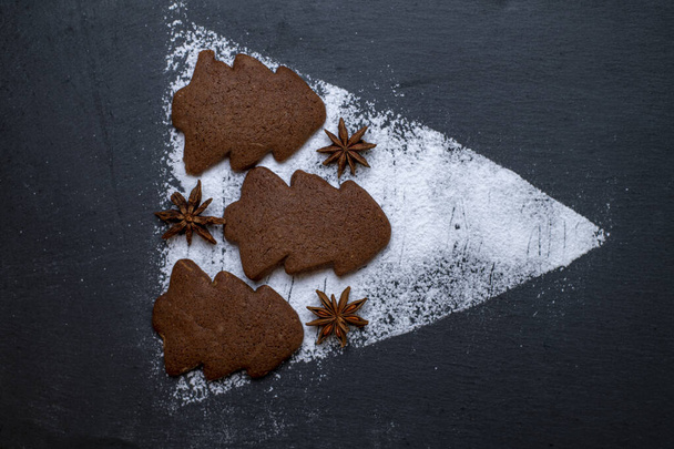 gingerbread cookies and powdered sugar on ardesia in the shape of a Christmas tree - Φωτογραφία, εικόνα