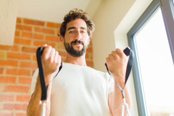 young bearded man doing exercise at home - 写真・画像