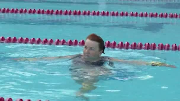 Старушка тренирует аква-гимнастику в бассейне. - Кадры, видео