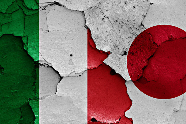 イタリアと日本の旗が割れた壁に描かれている - 写真・画像