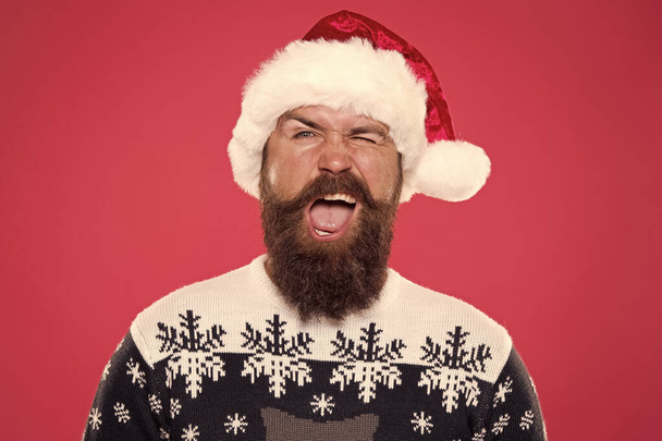 Best holiday. winking bearded man santa hat. brutal hipster favorite sweater red background. winter holiday fun. happy face mustache. portrait of santa man with beard. new year party. christmas time - Foto, Imagem