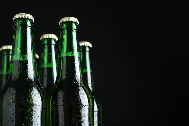 Bottles of beer on black background, closeup. Space for text - Foto, Imagem
