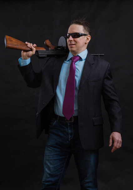 Mature gangster in sunglasses dressed in suit with tommy gun - Foto, immagini